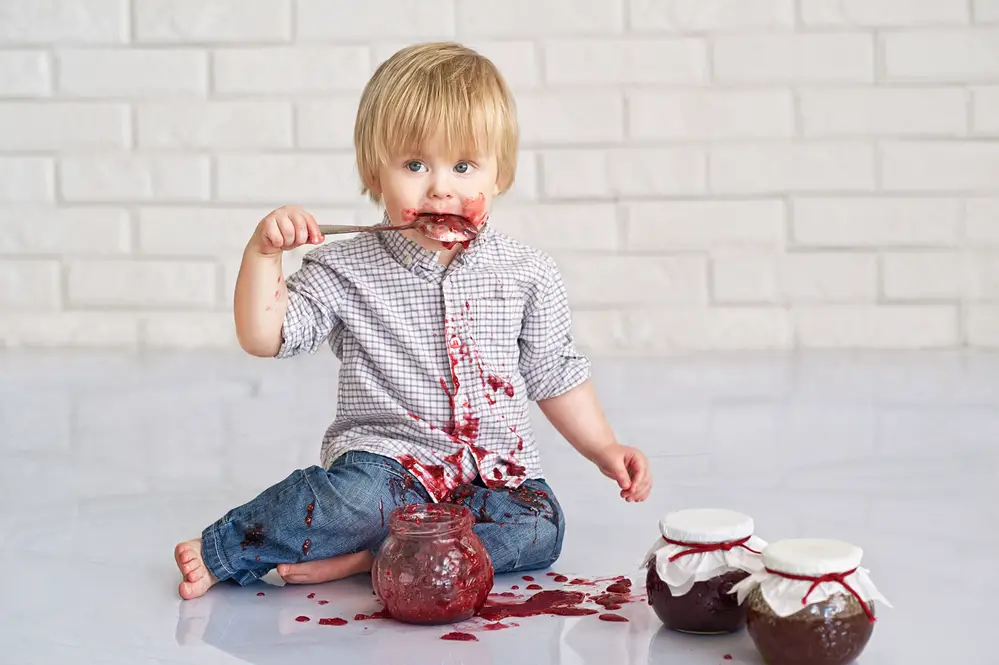 Bebé comiendo mermelada de fresa