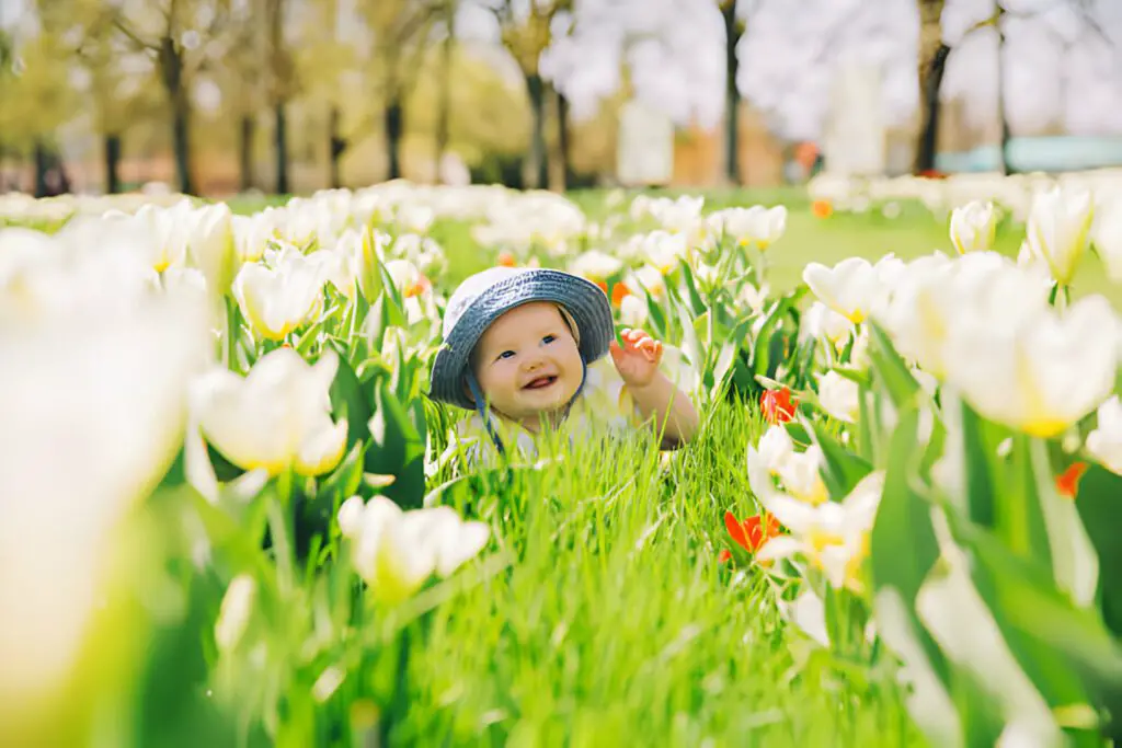 Bebé rodeado de flores en primavera